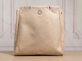 un sac fourre-tout beige posé sur une table en bois