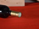 a bottle of wine sitting on a red table cloth
