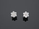 une paire de boucles d'oreilles en diamant sur une surface noire