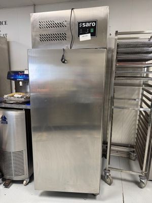 un réfrigérateur en acier inoxydable dans une cuisine où il y a beaucoup de nourriture