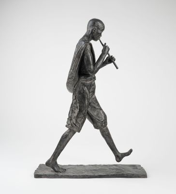 une statue en bronze représentant un homme marchant, une flûte à la main
