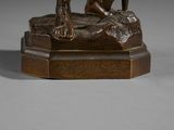bronze statue of a man with a dog on a rock