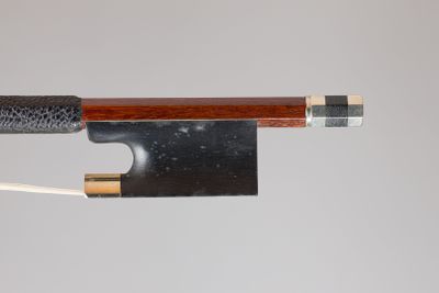 gros plan d'un archet de violon avec un morceau de bois qui en sort
