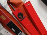 un téléphone portable noir posé sur une boîte rouge