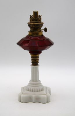 une lampe à l'ancienne surmontée d'un abat-jour en verre rouge