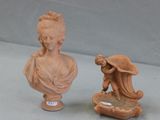 a small statue of a woman with a hat next to a small statue of a woman