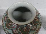 a vase with a design on it sitting on a table next to other items