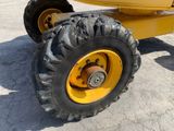 a large yellow truck with a big tire on the road