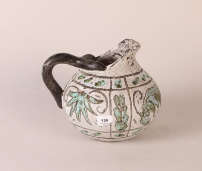 a white pitcher with a green and blue design on it
