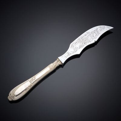 a silver knife on a black surface with a black background