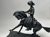 statue of a man riding a horse with a hat on top of it