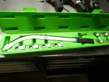 une mallette à outils verte, contenant des outils, posée sur une table