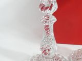 two glass candlesticks sitting next to a red box