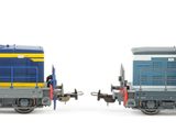 two toy trains sitting side by side on a white surface