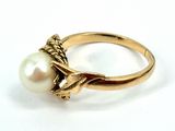 gold ring with a pearl in the center and a lion on the side
