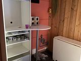 une petite cuisine équipée d'un réfrigérateur et d'une table