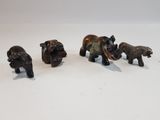 quatre petites figurines d'éléphants posées sur une surface blanche
