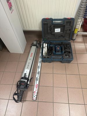 un ensemble d'outils posé à même le sol, à côté d'une boîte à outils