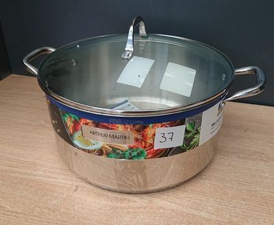 une casserole en inox avec un couvercle posée sur une table en bois