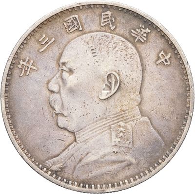 a close up of an old chinese coin with a man ' s face