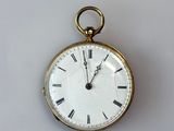 a gold pocket watch with roman numerals on the face