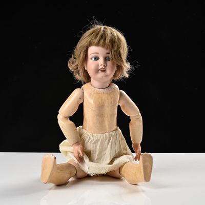 une petite poupée assise sur une table