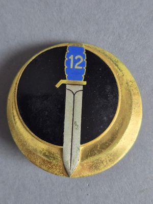 un insigne doré et bleu sur lequel figure une épée