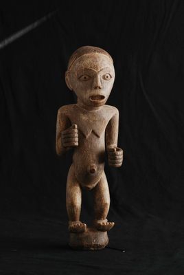 une statue en bois représentant un homme tenant un couteau à la main