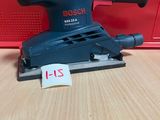 un gros plan d'une ponceuse orbitale Bosch posée sur une table en bois