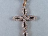 un gros plan d'un pendentif en forme de croix en diamant sur fond blanc