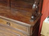 a wooden cabinet with a mirror on top of it