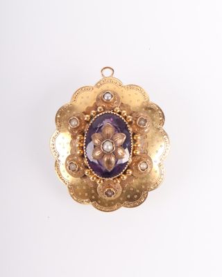une image représentant un pendentif en or et améthore, orné d'une pierre violette en son centre