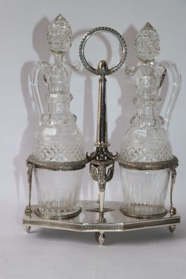 two glass decanters sitting on a silver stand