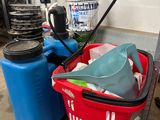 a red basket filled with cleaning supplies next to a blue container