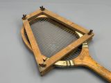 une vieille raquette de tennis en bois recouverte d'un filet