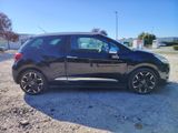 a picture of a small black car parked on the side of the road