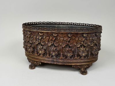an ornately carved metal bowl sitting on top of a table