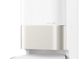 a close up of a white speaker with a remote on top of it