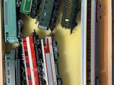 plein de petits trains miniatures dans une boîte posée sur la table