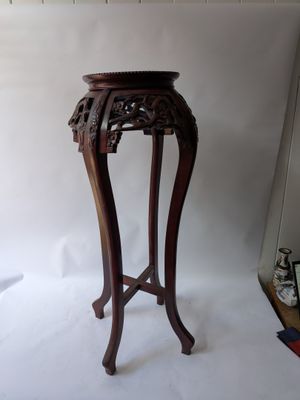 a small wooden table with a vase on top of it