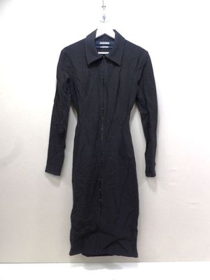 une robe noire suspendue à un cintre accroché au mur