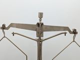 a metal balance scale with a pair of scissors on it