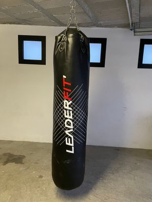 a black punching bag hanging from the ceiling in a garage