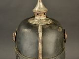 an old helmet on a stand on a gray background