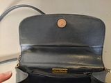 a person holding a black purse in their hand