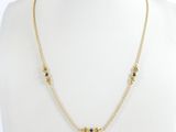 un collier en or orné de pierres noires autour du cou d'un mannequin