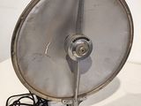 a metal fan sitting on a table with a cord attached to it