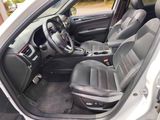 the interior of a car with the door open and the driver ' s seat down