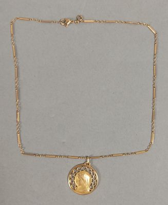 un collier en or avec une pièce de monnaie sur une chaîne