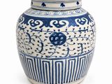 un vase bleu et blanc avec un couvercle, posé sur une surface blanche